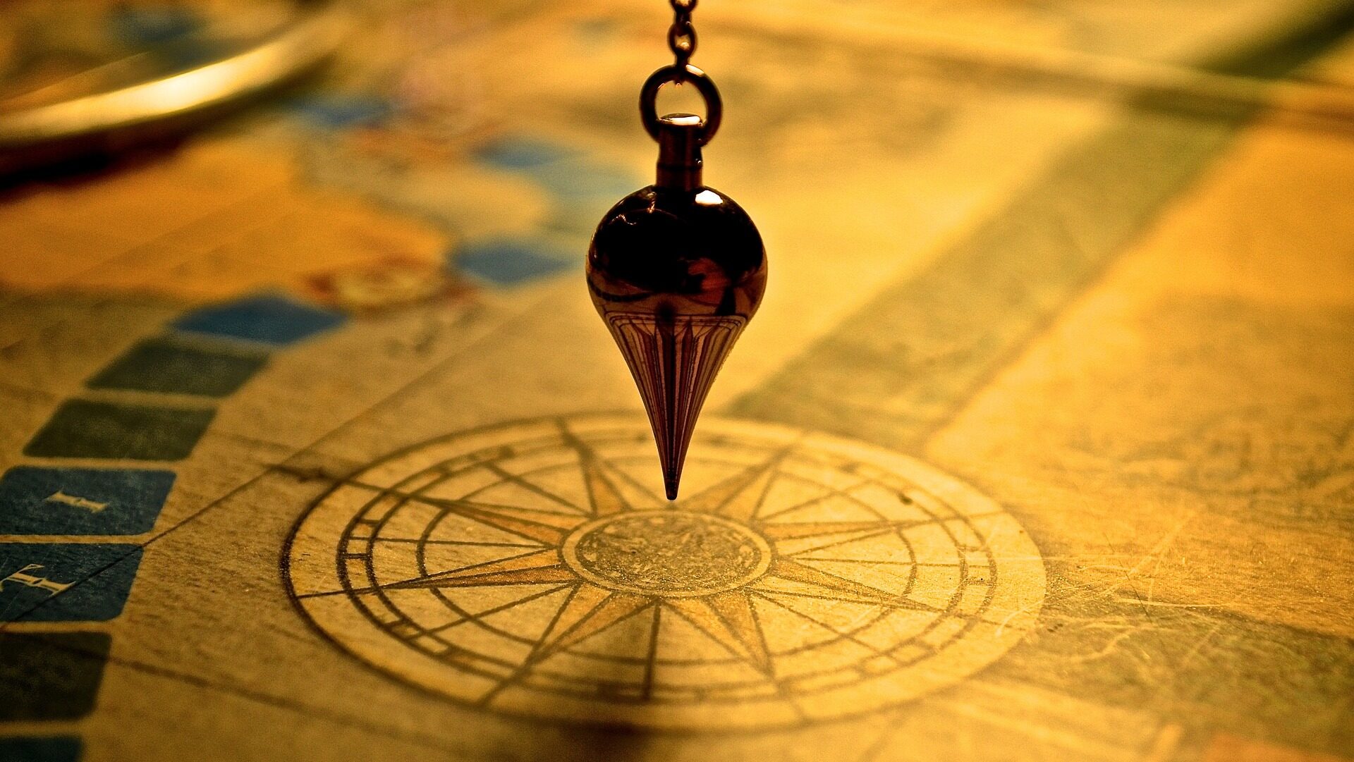 A pendulum hovers over a map as a navigational compass