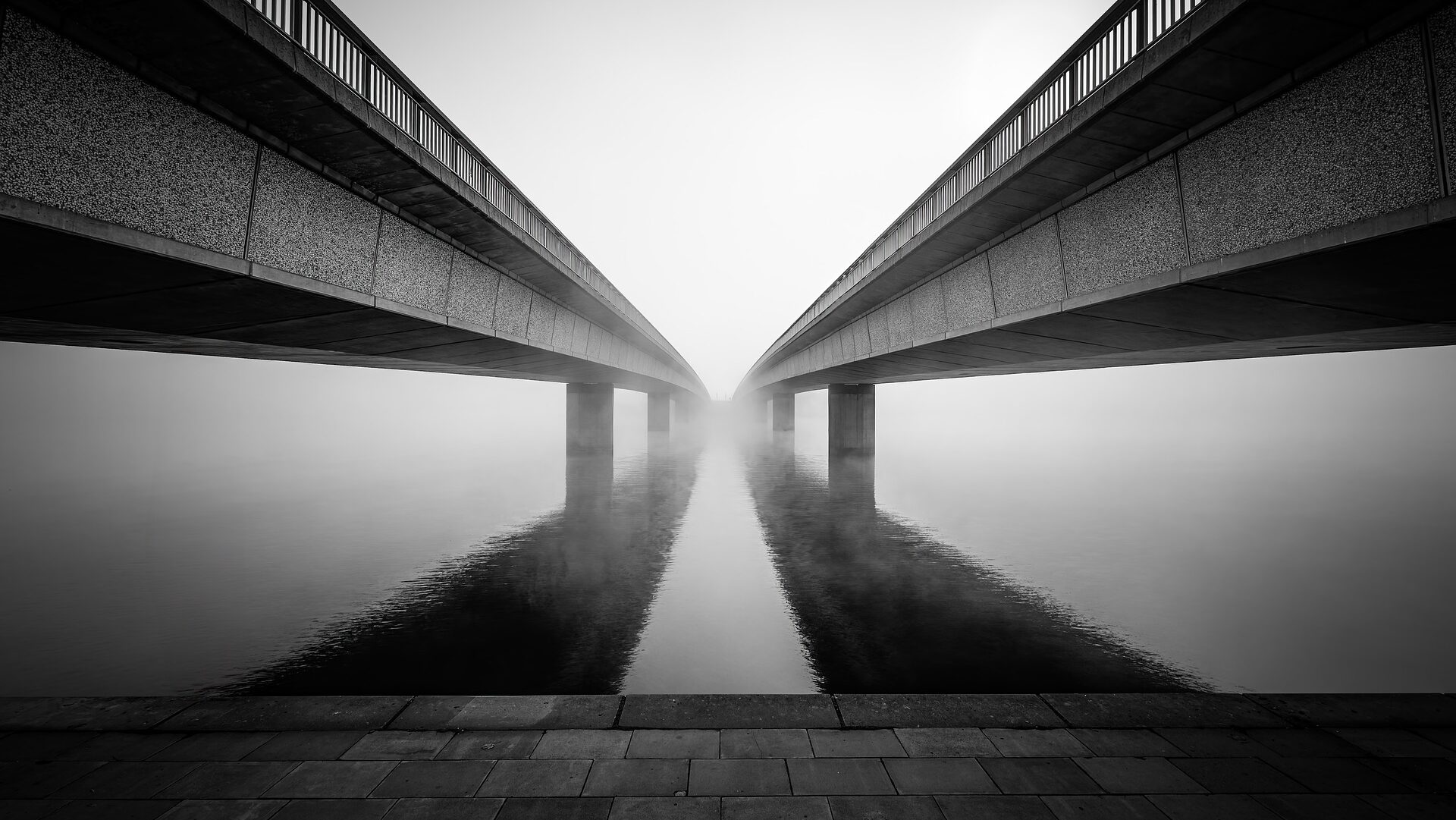 Light fog over water by two bridges