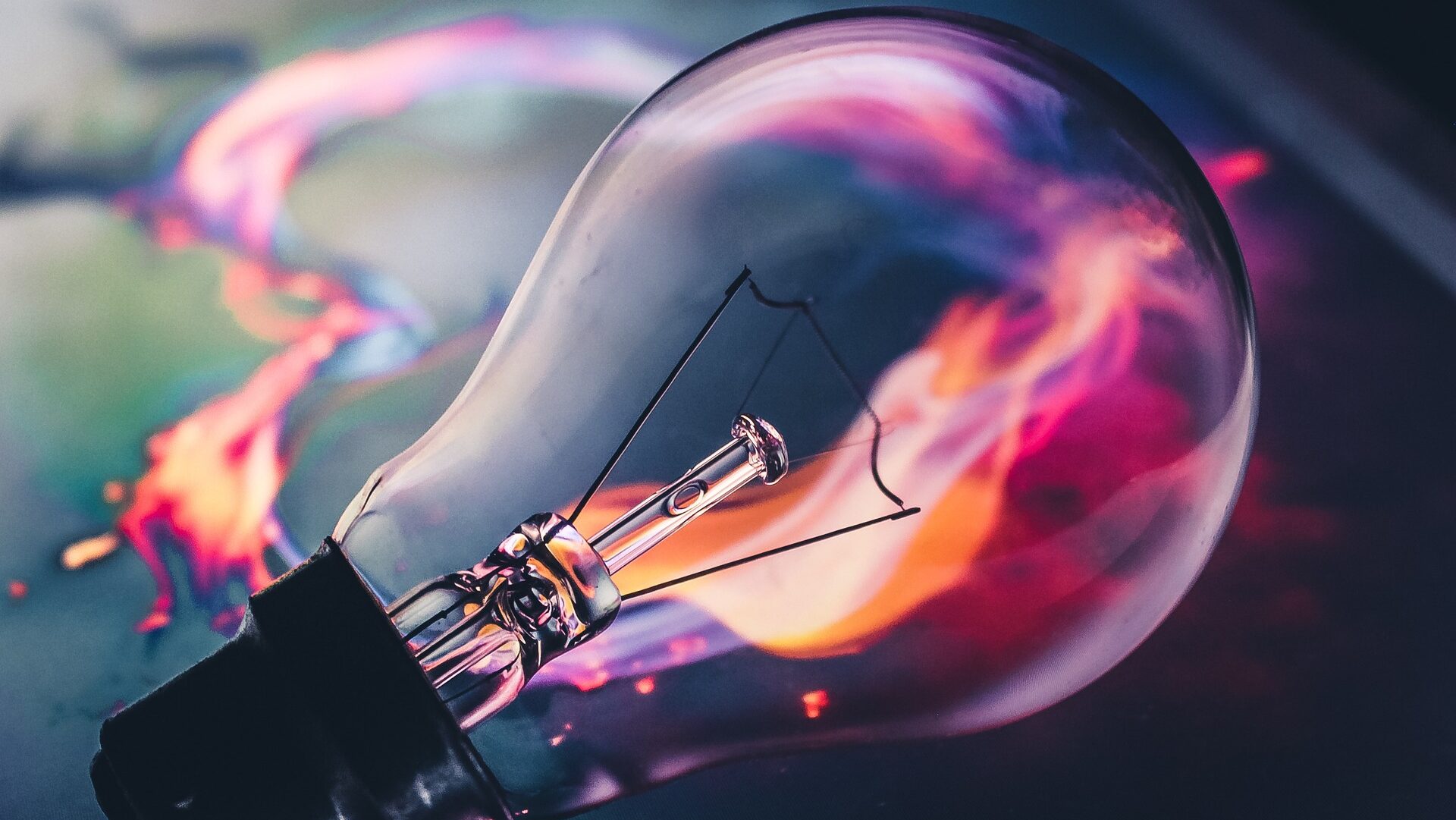 Clear lightbulb with flames in the background