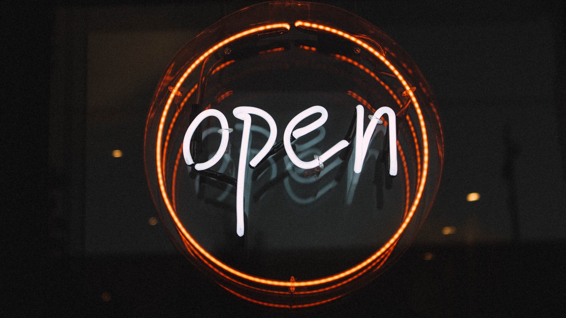 Neon sign in window that says Open in a red circle