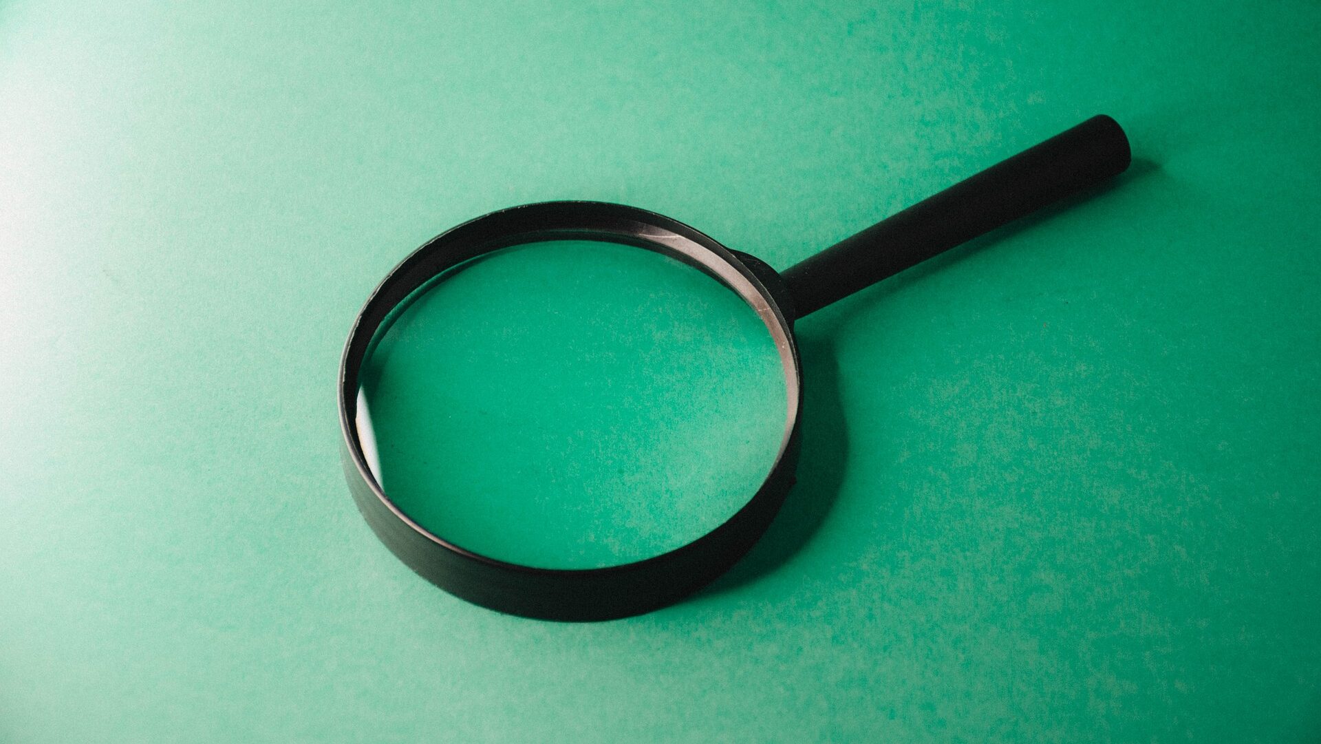 Magnifying glass on green background