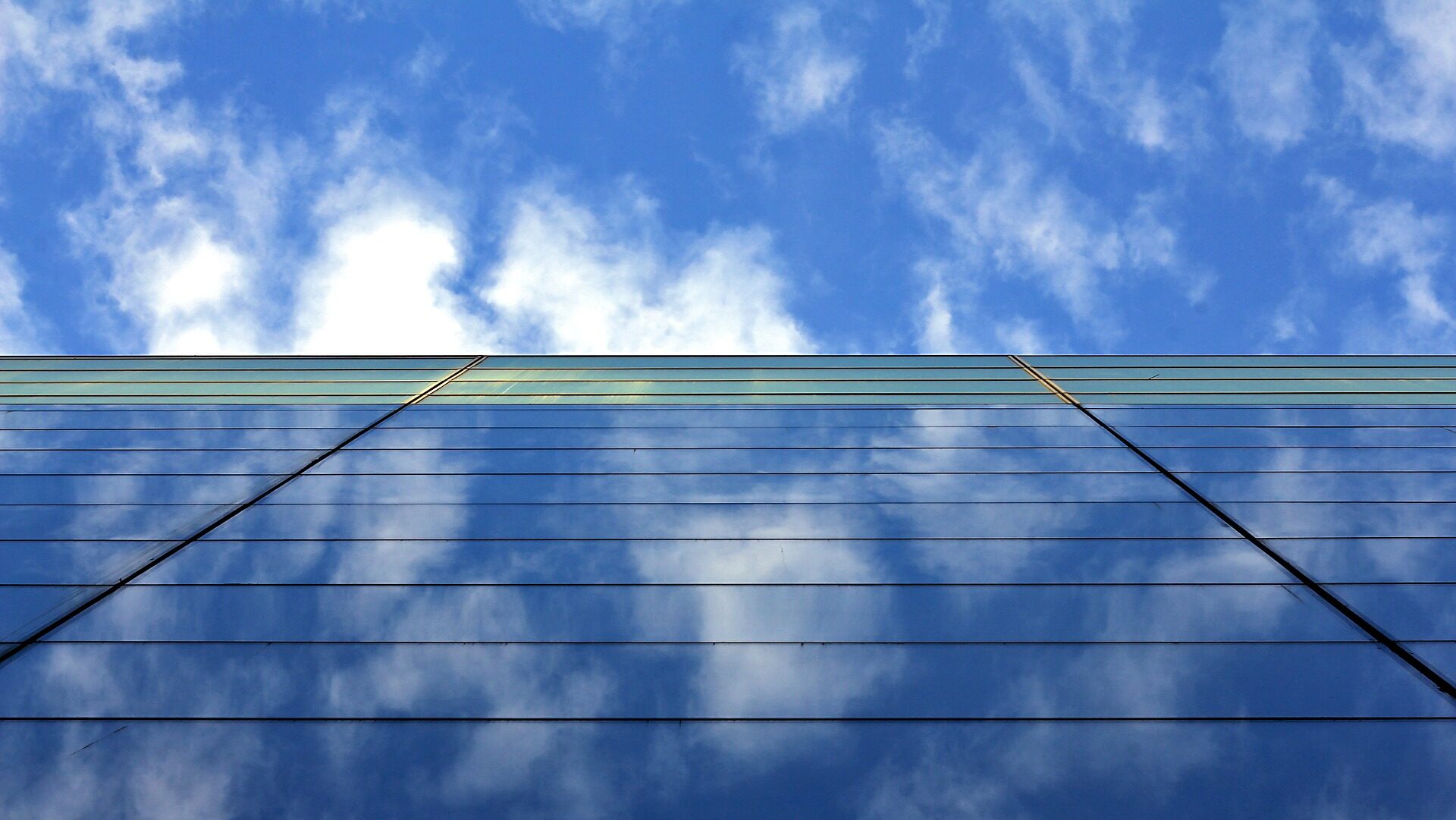 A building reflecting cloud in the sky.