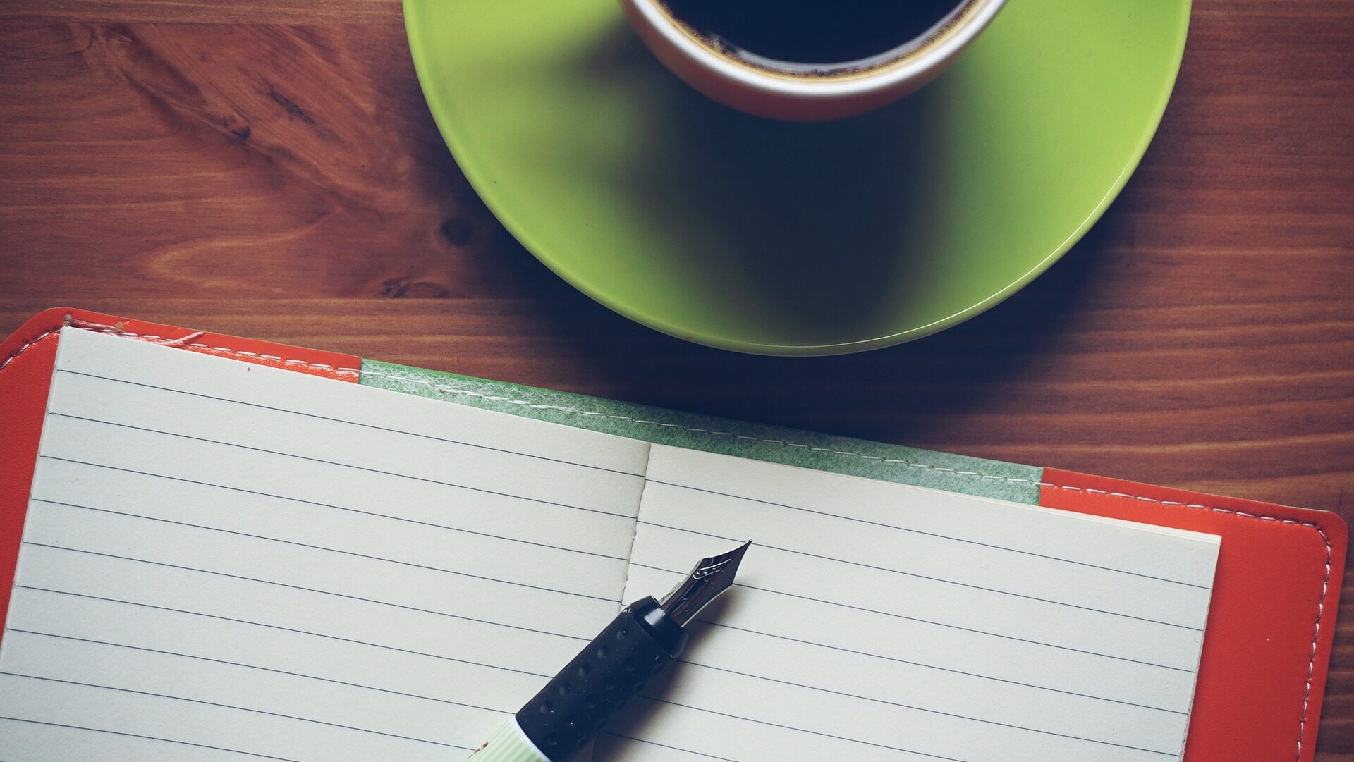 Blank pages of a notebook with a pen and cup of coffee