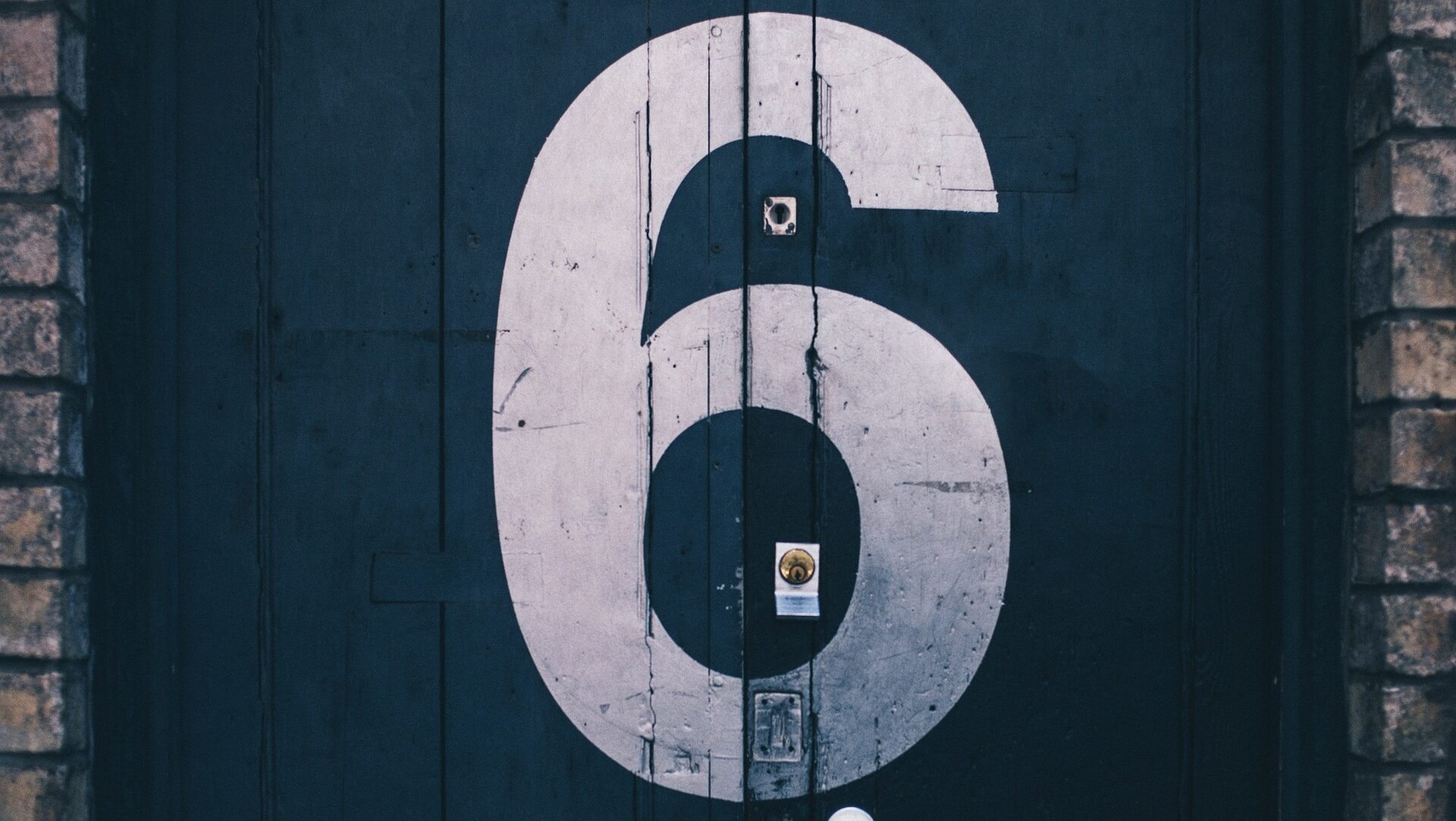 Black brick door with a large number 6 in white